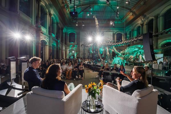 Zwei Forscherinnen des Museums im Gespräch mit Host Lukas Klaschinski auf einer Bühne im Sauriersaal zum Beats & Bones Podcast-Festival 2023